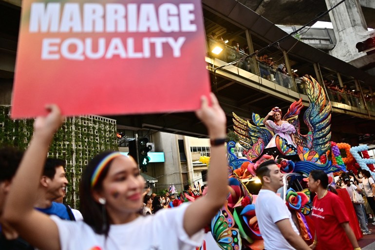 Campaigners carry signs calling for marriage equality in Bangkok.