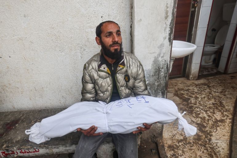A man holds the body of baby girl Aysal Daraz who was killed along with her eldest sister in an overnight Israeli air strike, on April 4