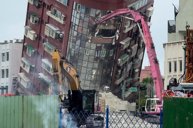 A bulldozer working on the teetering Uranus building in Hualien. The building is leaning to one side after its lower floors collapsed. 