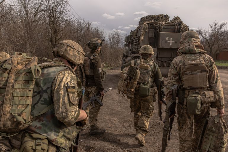 Ukrainian soldiers walking towards an armoured fighting vehicle on their way towards the front line in eastern Donetsk