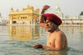 A Sikh devotee bathes in the holy sarovar (water tank) on Baisakhi, a spring harvest festival that also marks the Sikh new year, at the Golden Temple in Amritsar, India, on Saturday [Narinder Nanu/AFP]
