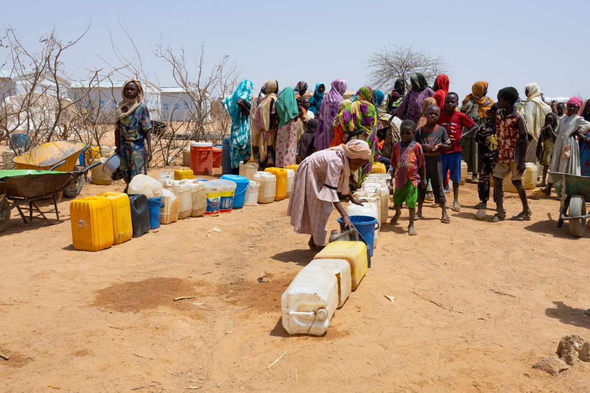 Sudanese refugees gather to get water from a water point in the Farchana refugee camp, on April 8