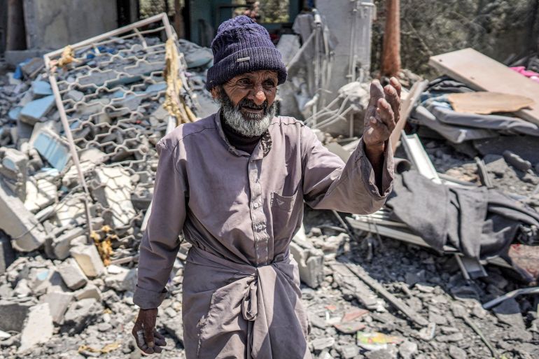 an old man in front of a destroyed building