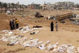 People gather near bodies lined up for identification after they were unearthed from a mass grave found in the Nasser Medical Complex in the southern Gaza Strip on April 25, 2024. [AFP]