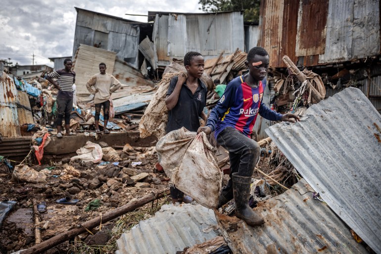 پس از سیل در نایروبی، پسران برخی از وسایل خود را حمل می کنند