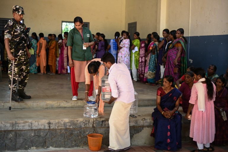 Autoridades providenciam água potável em uma seção eleitoral durante a segunda fase de votação das eleições gerais da Índia no distrito de Wayanad, em Kerala