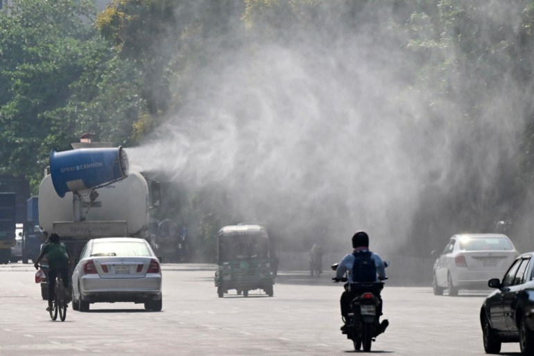 A vehicle of the Dhaka North City Corporation (DNCC) sprays water along a busy road to lower the temperature amidst a heatwave in Dhaka on April 27