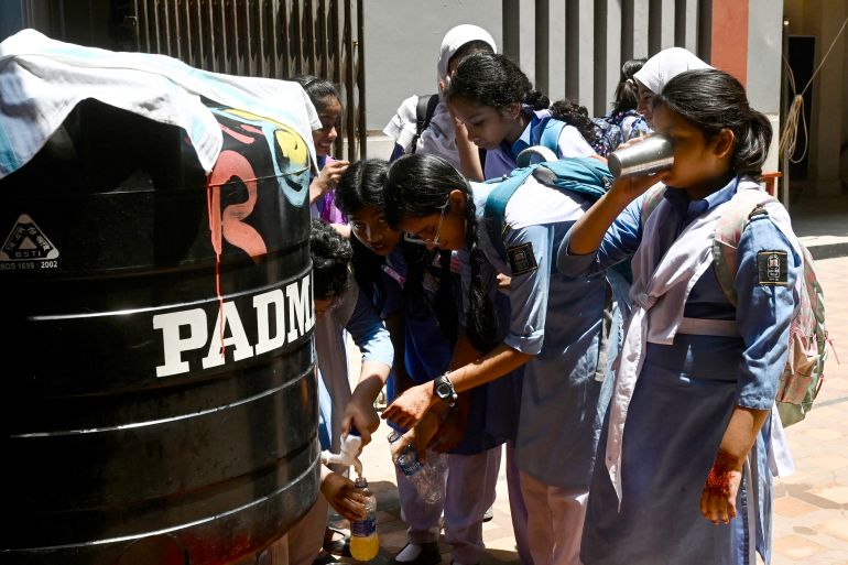 Students refill their bottles at a school in Dhaka