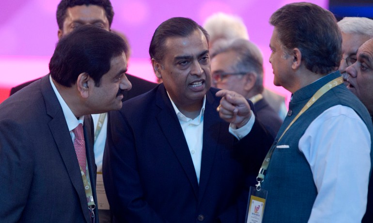 FILE- Adani Group Gautam Chairman Gautam Adani, left, Reliance Industries Chairman Mukesh Ambani, center, and Mahindra Group Chairman Anand Mahindra interact as they attend 'UP Investors Summit 2018' in Lucknow, India, Feb. 21, 2018. Asia’s richest man, Gautam Adani, made his vast fortune betting on coal as an energy hungry India grew swiftly after liberalizing its economy in the 1990s. He's now set his sights on becoming world's biggest renewable energy player, by 2030, adroitly aligning his investments with the government’s own priorities. (AP Photo/Rajesh Kumar Singh, File)