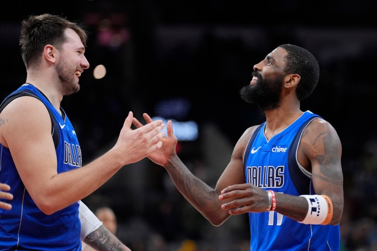 Luka Doncic and Kyrie Irving celebrate a victory.