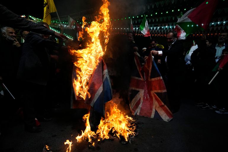 Iranian protesters burn representations of the British flag during their anti-Israeli gathering to condemn killing members of the Iranian Revolutionary Guard in Syria, at the Felestin (Palestine) Sq. in downtown Tehran, Iran.