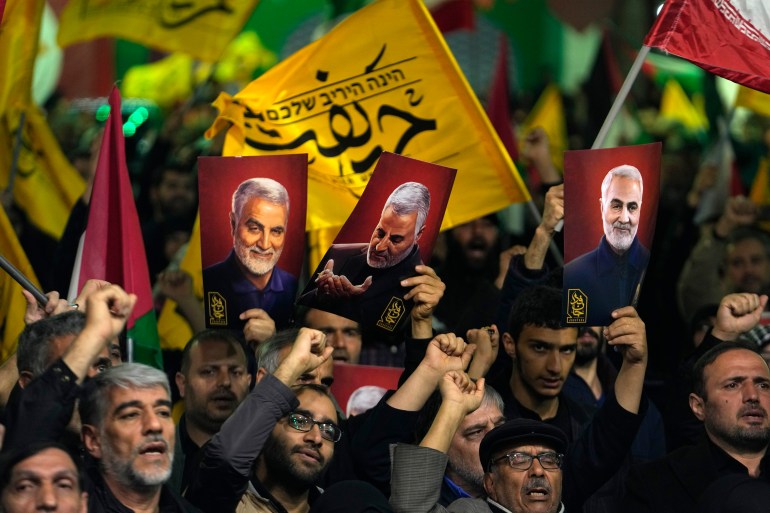 Protesters in Tehran. They are holding up posters of Iranian Revolutionary Guard Gen. Qassem Soleimani, who was killed in a US drone attack in 2020. 