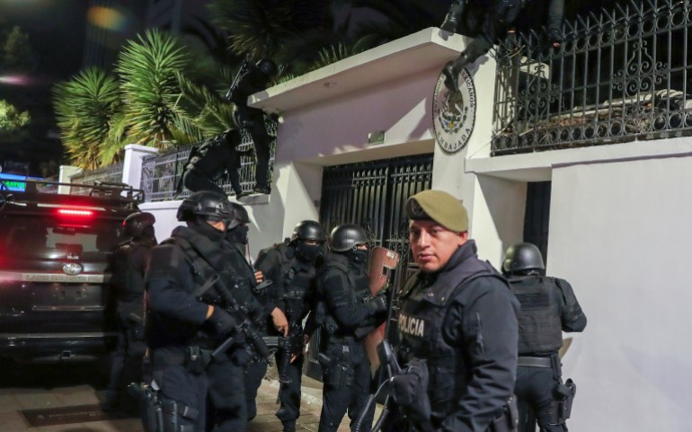 De politie verzamelt zich buiten de witte betonnen poort van de Mexicaanse ambassade in Quito.