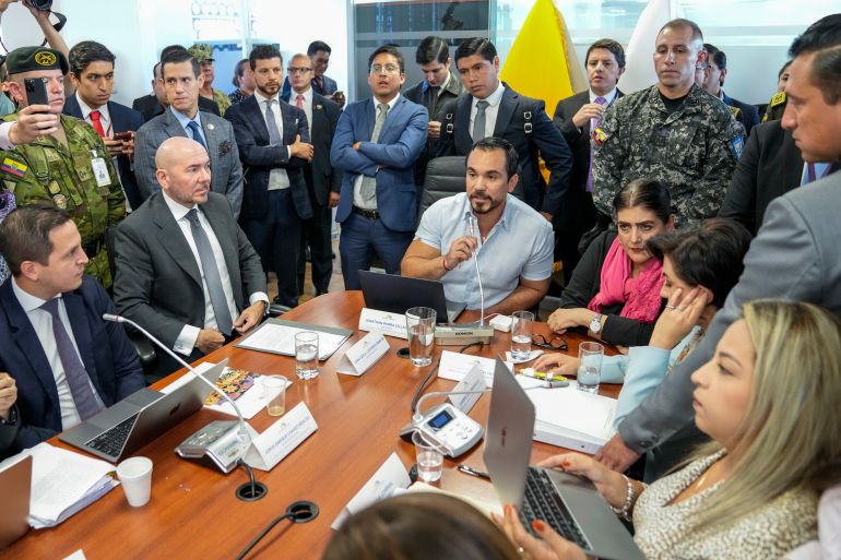 Ecuadorian officials gather around a conference table to discuss a raid on the Mexican embassy in Quito.