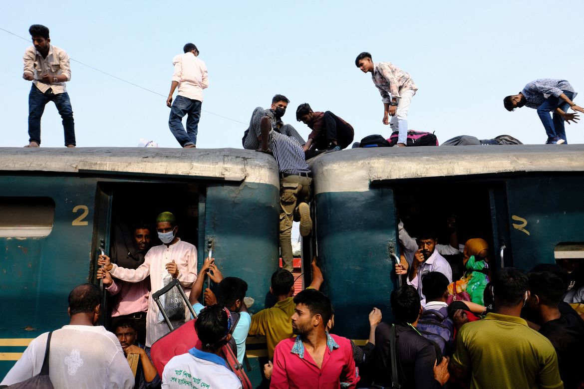 Bangladeshi Muslims maneuver their way on the roof of an overcrowded train to travel home for Eid al-Fitr celebrations, at a railway station in Dhaka, Bangladesh, Tuesday, April 9