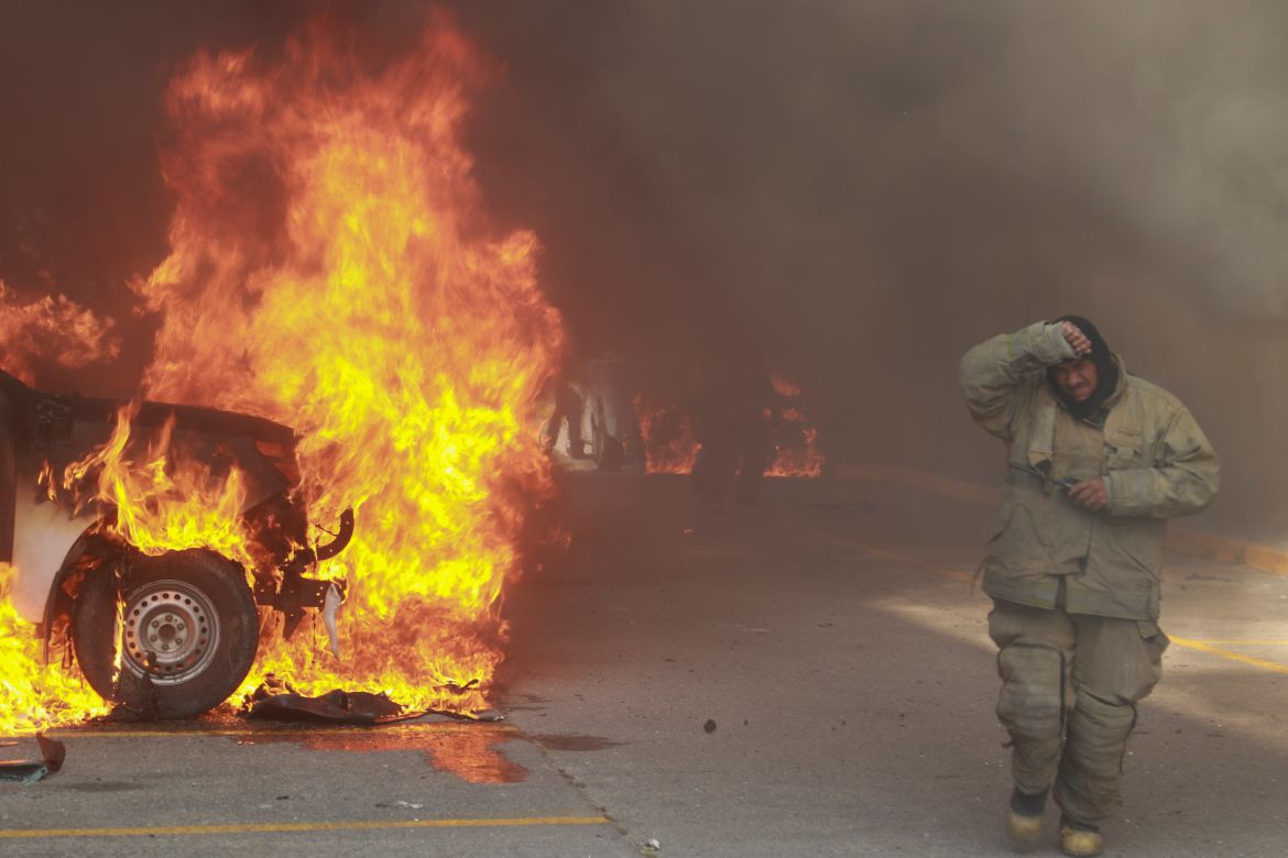 A truck burns after it was set on fire by rural teachers' college students protesting the previous month's shooting of one of their classmates during a confrontation with police, as firefighters work to control the blazes outside the municipal government palace in Chilpancingo, Mexico, April 8