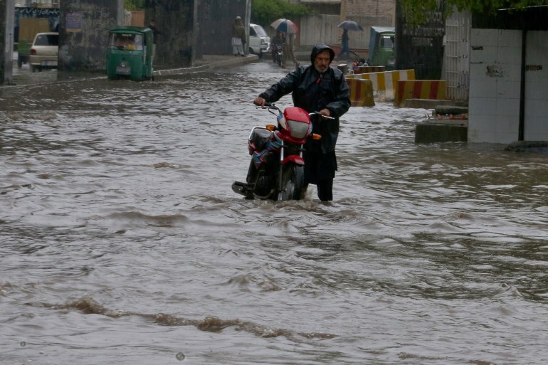 Ein Pakistaner watet mit seinem Fahrrad durch eine überflutete Straße, die durch starken Regen in Peshawar, Pakistan, am Montag, 15. April 2024, verursacht wurde. Blitze und heftige Regenfälle haben in den letzten drei Tagen in ganz Pakistan Dutzende Menschen, hauptsächlich Bauern, getötet, sagten Beamte am Montag. Als die Behörden nach einem nächtlichen Regenfall im Südwesten des Landes den Ausnahmezustand ausriefen, um weitere Opfer und Schäden zu vermeiden