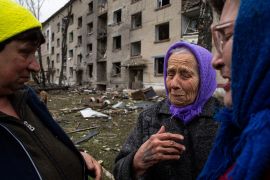 A Ukrainian woman cries as she says goodbye to her neighbours following a Russian missile attack [Evgeniy Maloletka/AP]