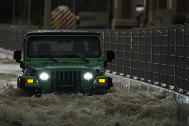 An SUV passes through standing water in Dubai, United Arab Emirates, Tuesday, April 16, 2024.