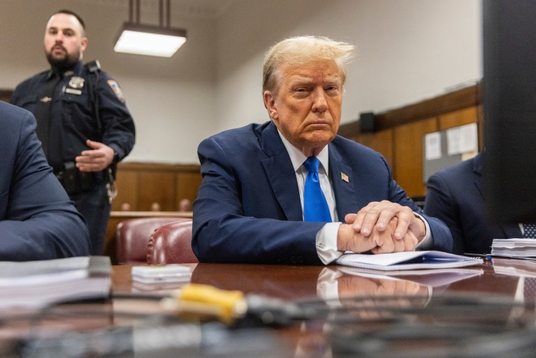 Трамп сидит за столом защиты в зале суда Манхэттена