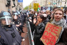 Police in riot gear stand guard as demonstrators chant slogans outside the Columbia University campus in New York on Thursday, April 18, 2024. The protesters were calling for the school to divest from corporations that they claim profit from the war in the Middle East [Mary Altaffer/AP Photo]