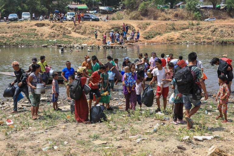 People cross the Moei river as they flee Myawaddy township