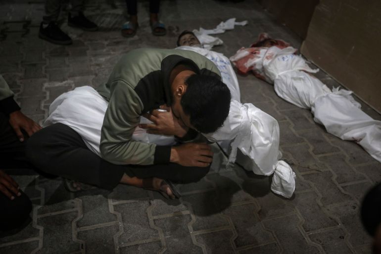 A Palestinian youth mourns his relative killed in the Israeli bombardment of the Gaza Strip, at the morgue of the Kuwaiti Hospital in Rafah refugee camp, southern Gaza Strip, early Saturday, April 20, 2024.