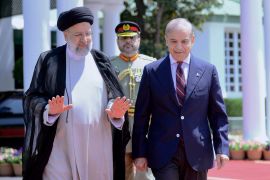 Iranian President Ebrahim Raisi, left, walks with Pakistan&#039;s Prime Minister Shehbaz Sharif during a welcome ceremony in the prime minister house in Islamabad on April 22. [Prime Minister Office via AP]