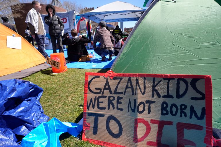 A sign calling attention to the conflict in Gaza rests against a tent, Thursday, April 25, 2024, at an encampment of tents on the Massachusetts Institute of Technology campus, in Cambridge, Mass. Students at MIT set up the encampment of tents on the campus to protest what they said was MIT's failure to call for an immediate ceasefire in Gaza and to cut ties to Israel's military. (AP Photo/Steven Senne)