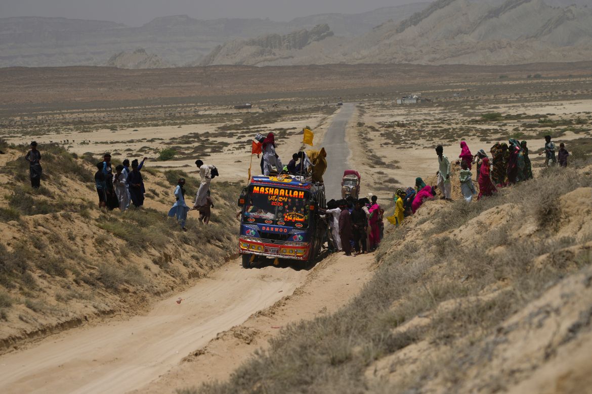 Hindu devotees get off from a bus and walk toward a mud volcano, to start Hindu pilgrims religious rituals for an annual festival in an ancient cave temple of Hinglaj Mata in Hinglaj in Lasbela district in the Pakistan's southwestern Baluchistan province, Friday, April 26