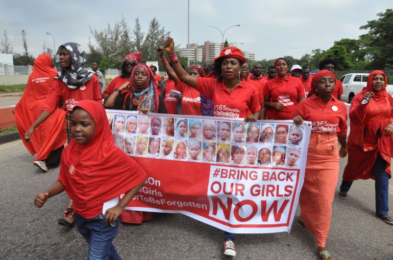 Protesters hold banners depicting missing girls from Chibok