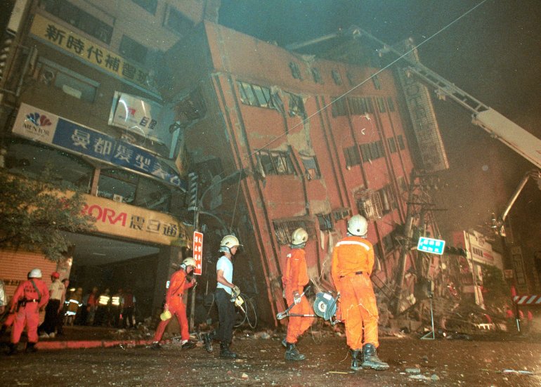 Taiwanese firemen and emergency workers inspect a collapsed 12-story hotel after an early morning earthquake, Tuesday, September 21, 1999, in Taipei. The U.S. Geological Survey National Earthquake Information Center said the quake had a preliminary magnitude of 7.6 and was centered 145 kilometers (90 miles) southwest of Taipei. (AP Photo/Wally Santana)
