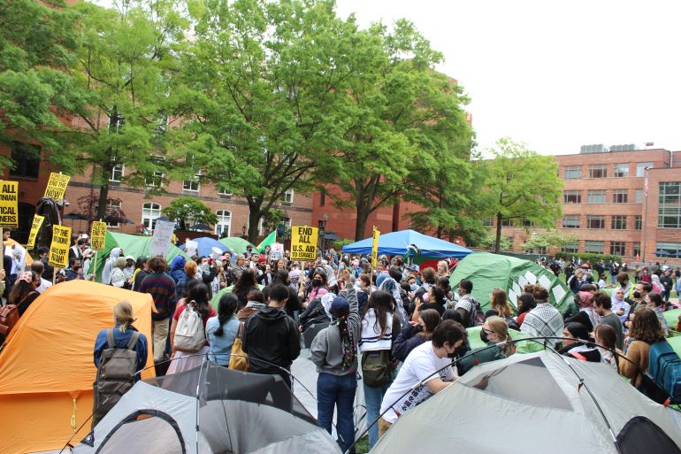Student protesters standing among tents