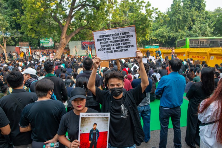 People from the Kuki-Zo Tribe community are holding placards and protesting against the violence in Manipur at Jantar Mantar in Delhi, India