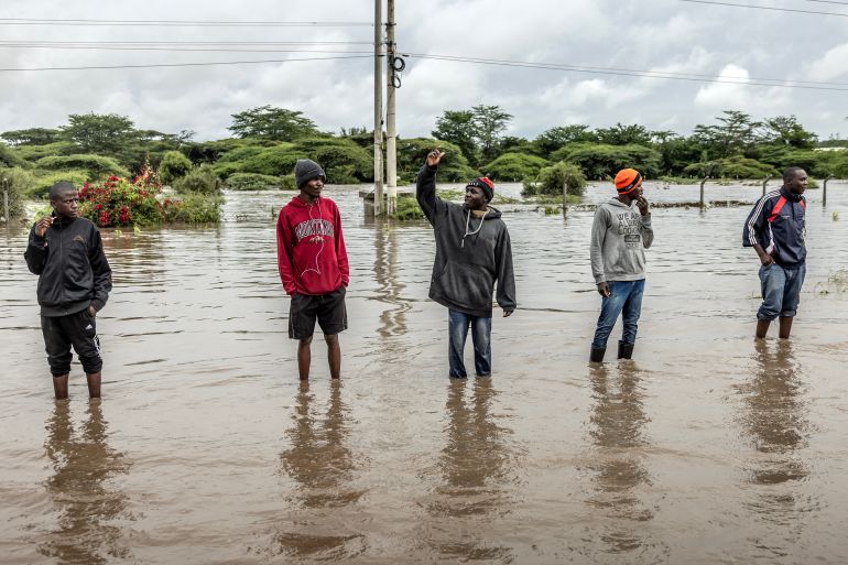 Residents inspect a road heavily affected by floods following torrential rains in Kitengela,