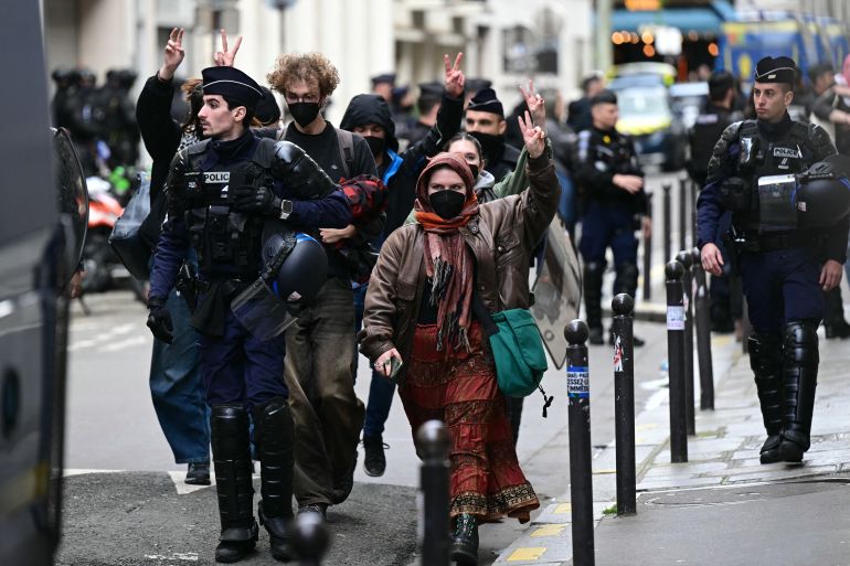 Protesters flash the sign of victory as they are escorted away by French gendarmes during the evacuation of a pro-Gaza sit-in in the entrance hall of the Institute of Political Studies (Sciences Po Paris) in Paris on May 3, 2024. One student told reporters that around 50 students were still inside the rue Saint-Guillaume site when police entered. Students at Sciences Po have staged a number of protests, with some students furious over the Israel-Hamas war and ensuing humanitarian crisis in the besieged Palestinian territory of Gaza. (Photo by MIGUEL MEDINA / AFP)