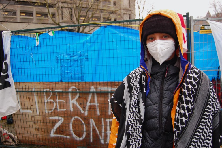McGill University student Sasha Robson poses for a photo in front of a sign reading 'Liberated Zone' at the Gaza protest encampment on campus