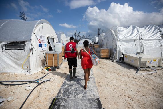 A healthcare worker walks with a person at the Spanish field hospital in Falmouth, Jamaica