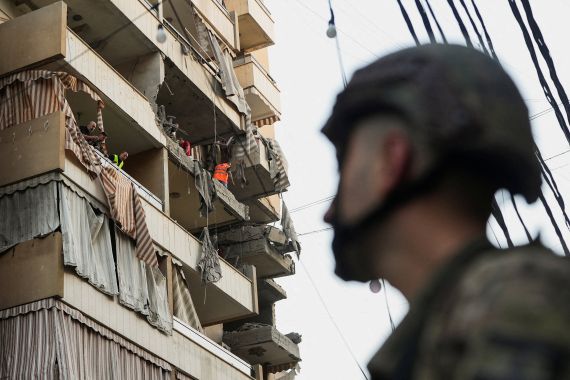 People inspect a damaged building, after Israeli military said on Sunday that it struck a militant from the Lebanese Iran-aligned Hezbollah group, in Beirut's southern suburbs, Lebanon November 23, 2025.