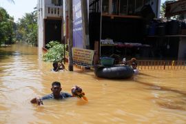 People wade through a flooded street, following Cyclone Ditwah in Kelaniya, Sri Lanka [Thilina Kaluthotage/Reuters]