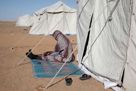A Sudanese woman displaced from el-Fasher sits outside his tent at the newly established el-Afadh camp in al-Dabbah, in Sudan&#039;s Northern State, Sunday, November 16, 2025 [Marwan Ali/AP Photo]