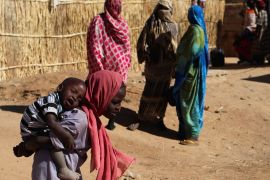 A Sudanese refugee girl carries her brother, at the Iridimi refugee camp northwest of Iriba, in Wadi Fira province, eastern Chad. [Amr Abdallah Dalsh/Reuters]