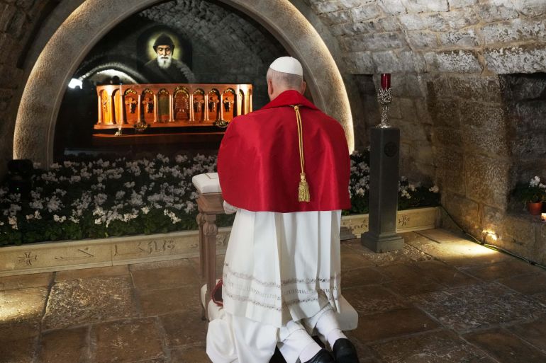Pope Leo XIV prays in front of the tomb of Saint Charbel Makhlouf at the Monastery of Saint Maroun, in the mountainous village of Annaya on December 1, 2025. [Domenico Stinellis/Pool via AFP] (AFP)