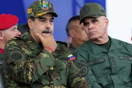 Venezuelan President Nicolas Maduro, left, listens to Defence Minister Vladimir Padrino Lopez during a government-organised civic-military march in Caracas, Venezuela, on Tuesday [Ariana Cubillos/AP Photo]