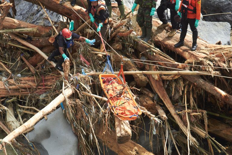 Rescuers use ropes to evacuate the body of a flood victim in Tanah Datar, West Sumatra, Indonesia, Monday, Dec. 1, 2025. (AP Photo/Nazar Chaniago)