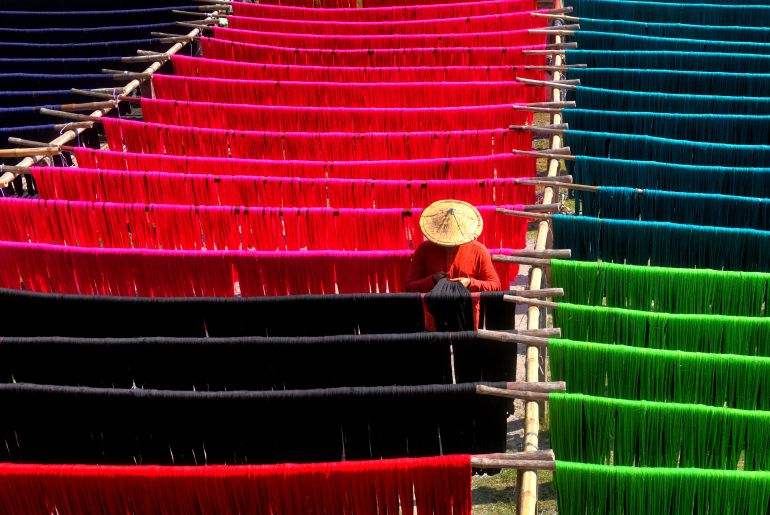 A weaver in West Bengal state rinses the colourful jute fibre to dry under the sun, which will be used to extract threads to make handloom dresses