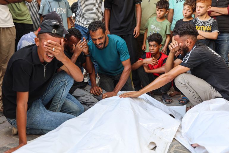 Mourners grieve next to the bodies of three Palestinians during their funeral at al-Shifa Hospital in Gaza City on October 25, 2026, after they were killed in an Israeli strike on the Islamic University building [AFP]