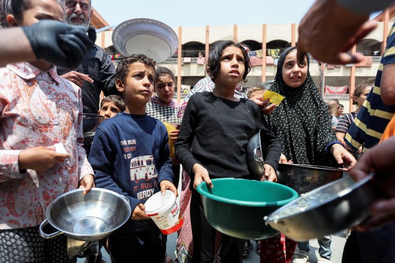 Palestinians gather to receive food meals cooked by World Central Kitchen (WCK) after the charity resumed operations, at a school sheltering displaced people, amid the ongoing conflict between Israel and Hamas, in Deir Al-Balah in the central Gaza Strip May 1, 2024. REUTERS/Ramadan Abed