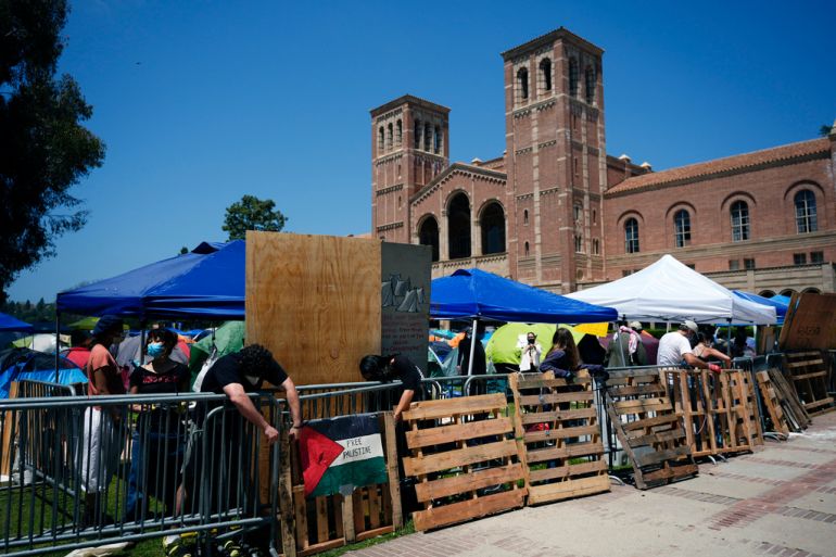 Pro-Palestine demonstrators restore a protective barricade at UCLA