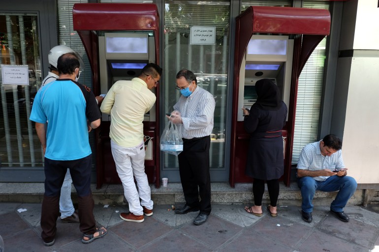 Men using ATM machines in Iran
